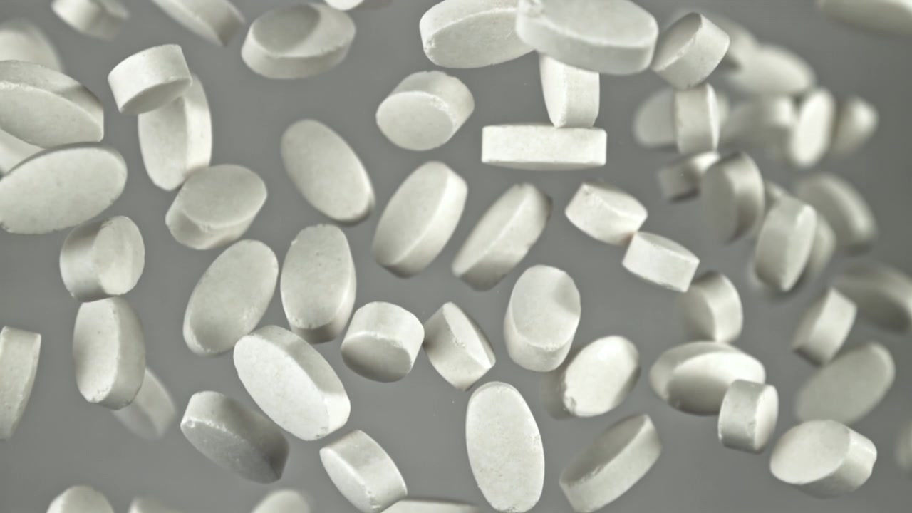 Pillole farmaceutiche bianche che cadono al rallentatore