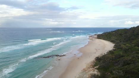 panorama of cylinder beach with tourists - headland in point lookout, qld, australia
