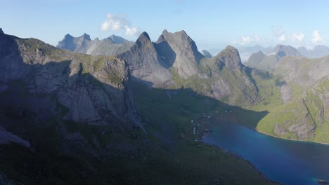 Drone-shot-of-Lofoten-steep-cliffs-and-mountains-rising-from-deep-blue-fjord