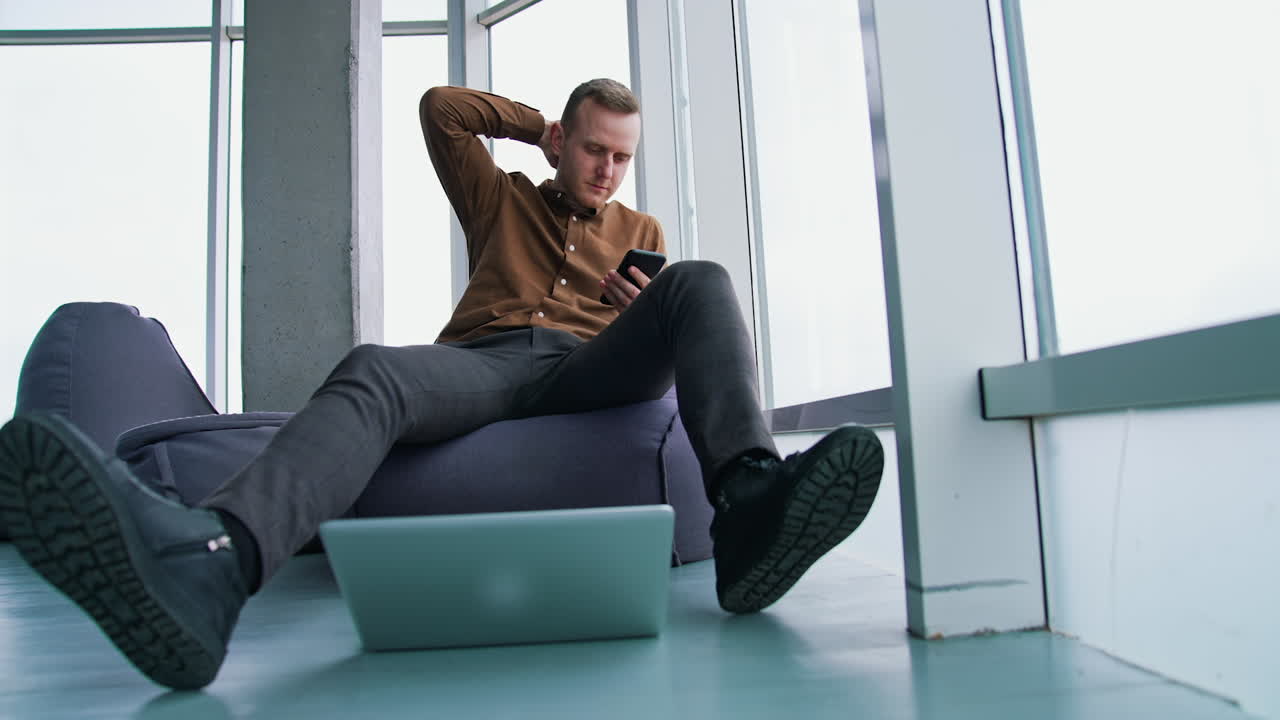 Typing business message. Young modern businessman using smartphone while sitting in the office
