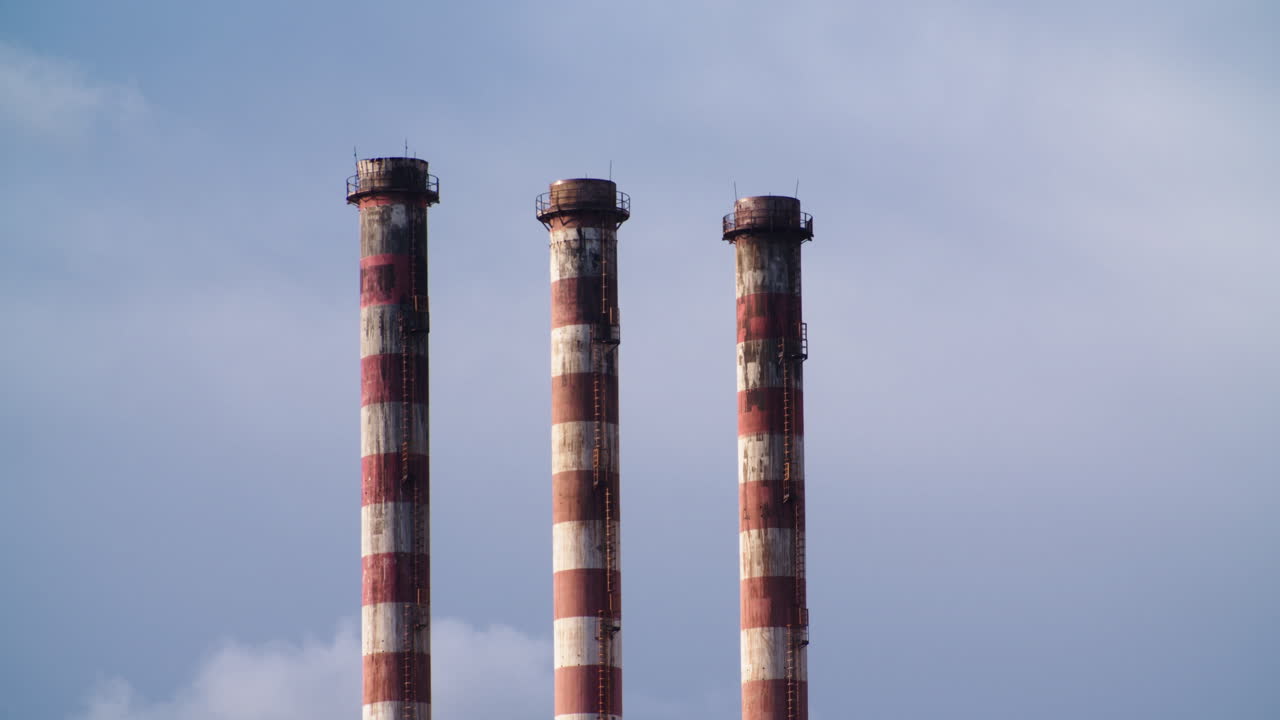 Three pipes industrial chimneys on blue sky background, day, static