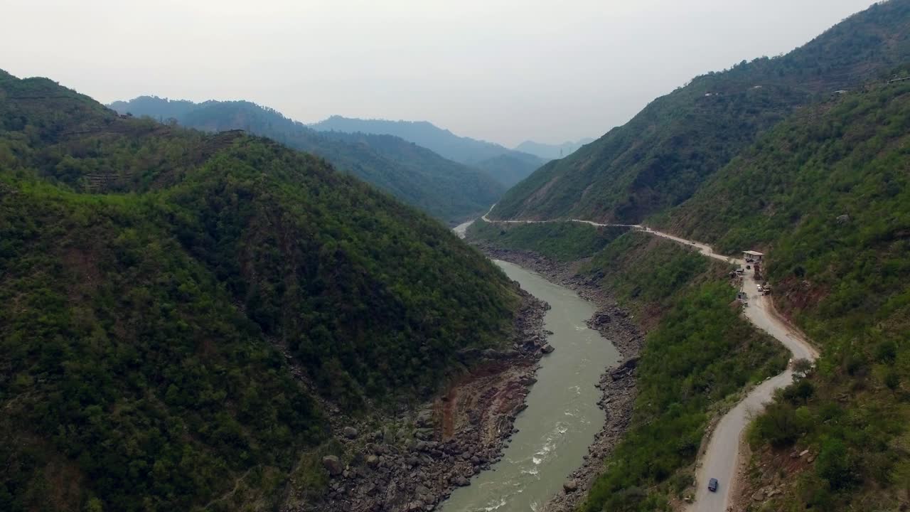 un río y un camino que van juntos entre las montañas