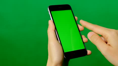 businesswoman using a blank green screen mobile phone on green background.