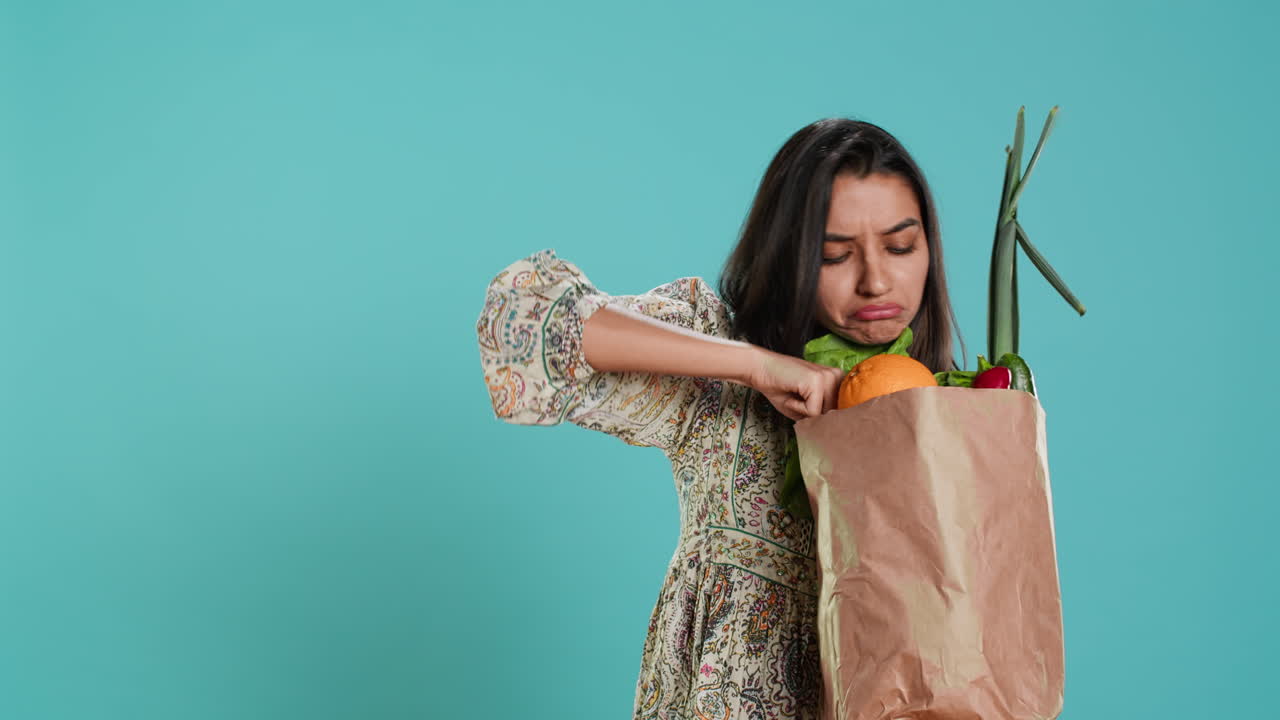 mujer con una bolsa de papel ecológico en las manos mirando pimienta,