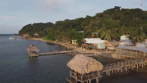 vuelo de la hora dorada más allá de la hierba techo de paja playa muelle cabañas en roatan