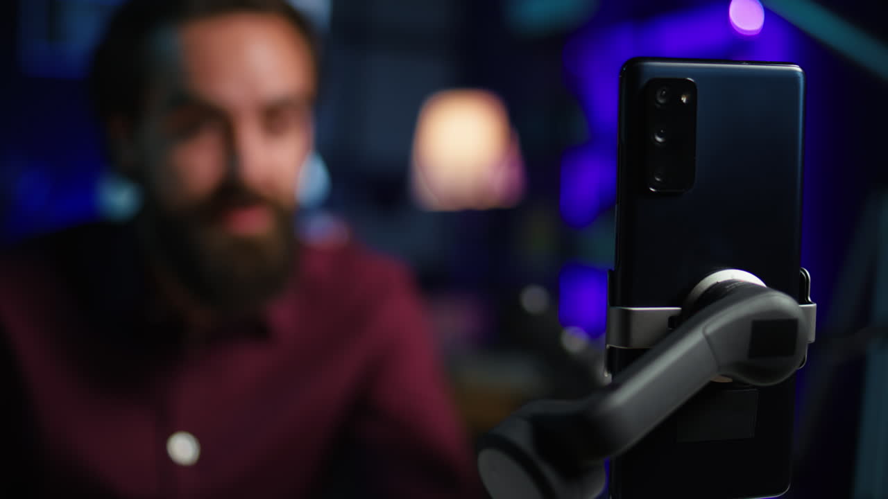 enfoque en el teléfono móvil utilizado por la estrella de los medios de comunicación utilizando en selfie palo para filmar vlog