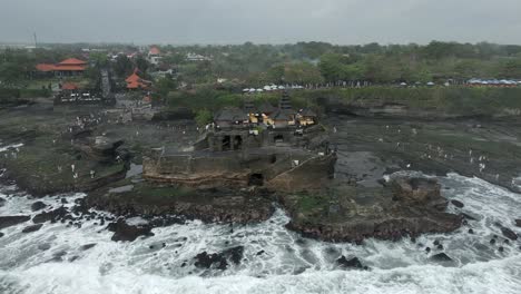 flat light grey day aerial view of tanah lot hindu temple, bali coast