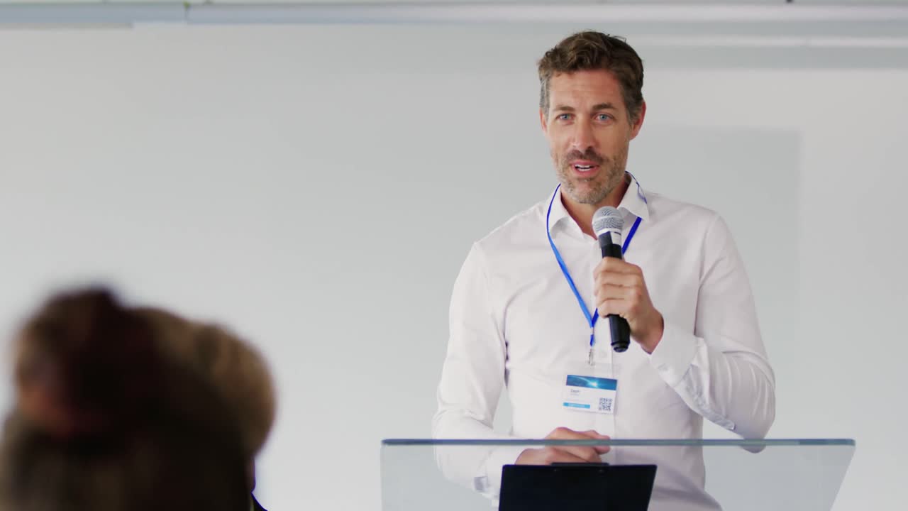 Male speaker addressing the audience at a business conference