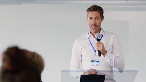 orador masculino dirigiéndose a la audiencia en una conferencia de negocios