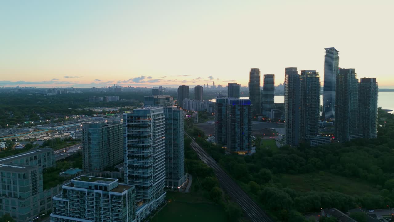 Drone shot pulling back over Parklawn high rises at sunrise with Lake Ontario and downtown skyline in view