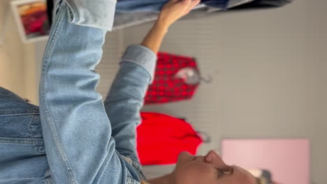 young caucasian woman looking at clothing, hanging on hangers. shopping in women’s clothing store. hd video