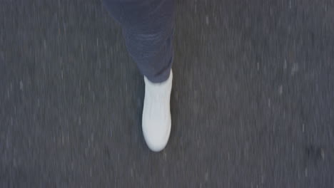 woman walking on asphalt road wearing white shoes strolling casual in city above view