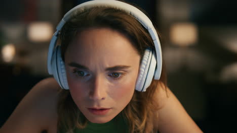 worried woman looking computer at home closeup. headphones lady feeling shocked