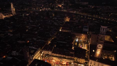 aerial backward drone view of piazza erbe and lamberti's tower at night verona