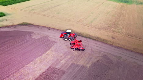 agricultural tractor with trailer ploughing on agricultural field