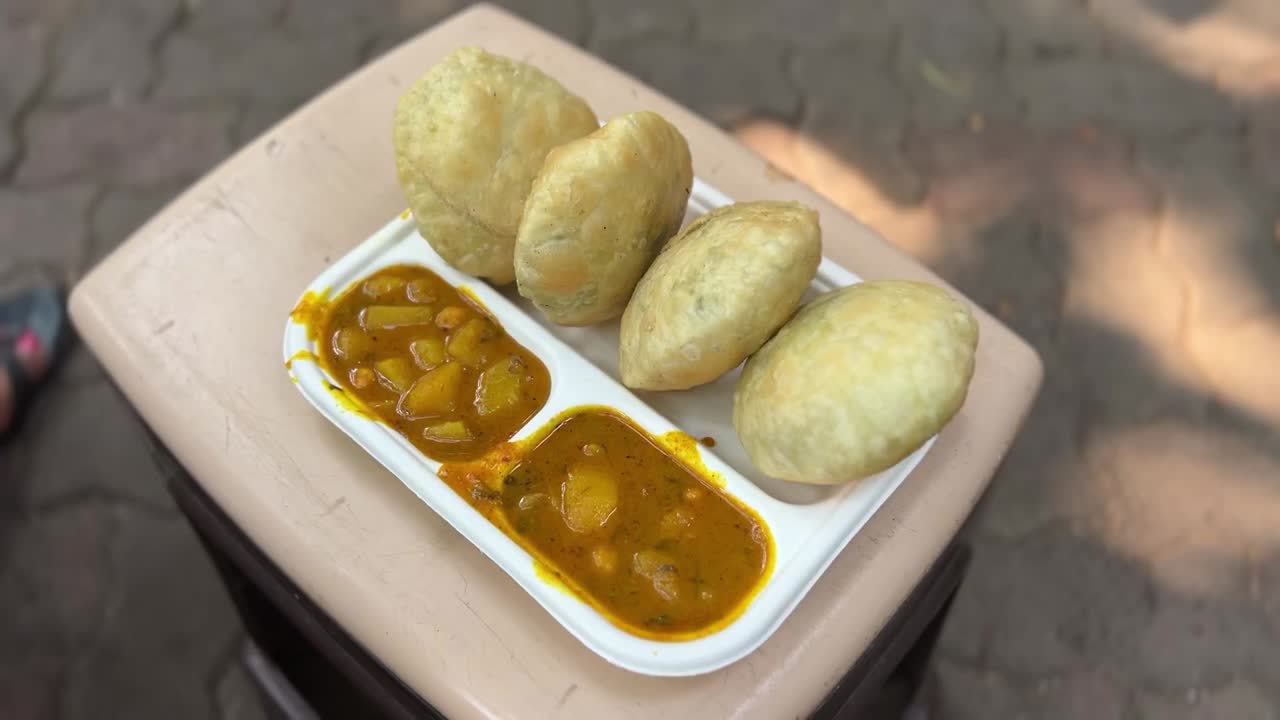 Peas kachori served with alu sabji in a white plate in Kolkata.