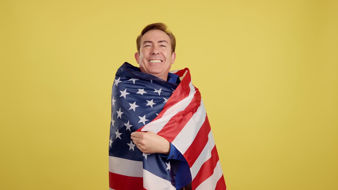 Man proudly wrapped in American flag against yellow background
