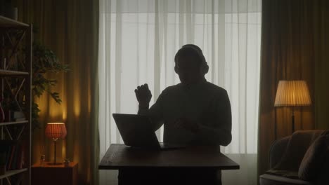 man working from home at night with headphones