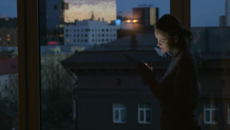 Mädchen-Arbeitet-Nachts-Mit-Pad-Am-Fenster