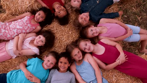 grupo multiétnico de niños acostados en círculo sobre paja