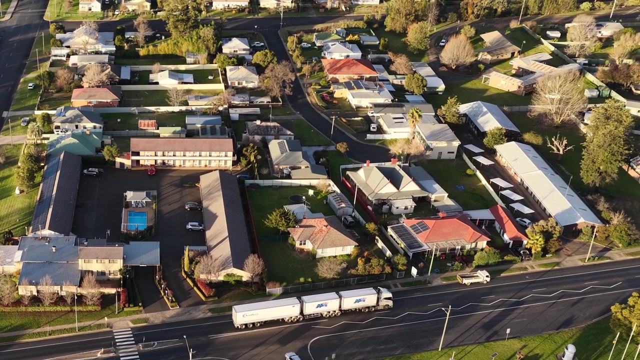 Ripresa aerea dall'alto di un grande camion che attraversa strade residenziali a Coonabarabran, Australia