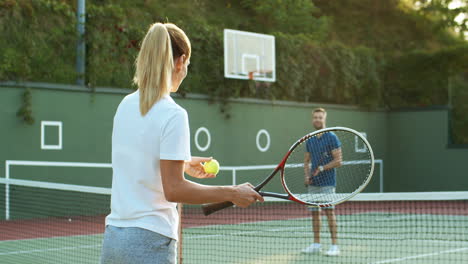 Happy-Family-Playing-Tennis-On-An-Outdoor-Court-In-Summer