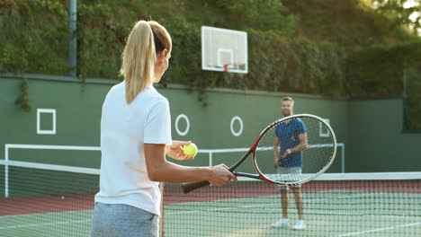 happy family playing tennis on an outdoor court in summer