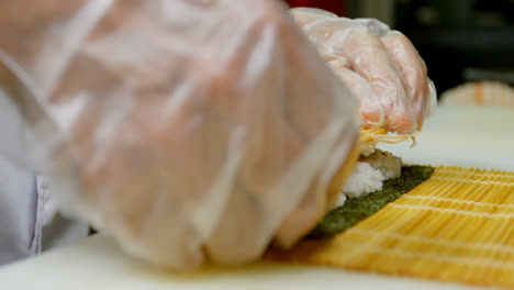 chef masculino preparando un rollo de arroz en la cocina 4k