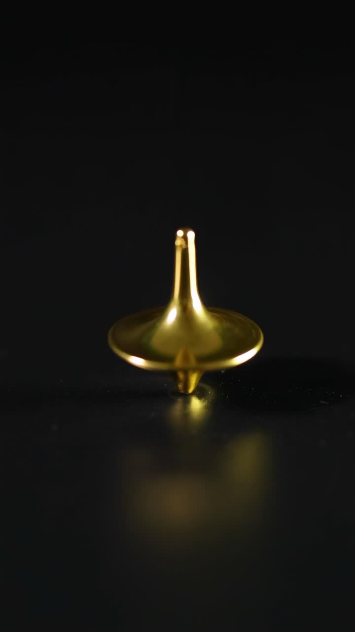 Pião dourado girando em uma superfície preta