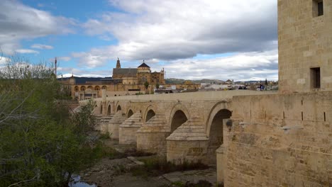 People-walking-over-famous-Roman-bridge-in-Cordoba-on-cloudy-day