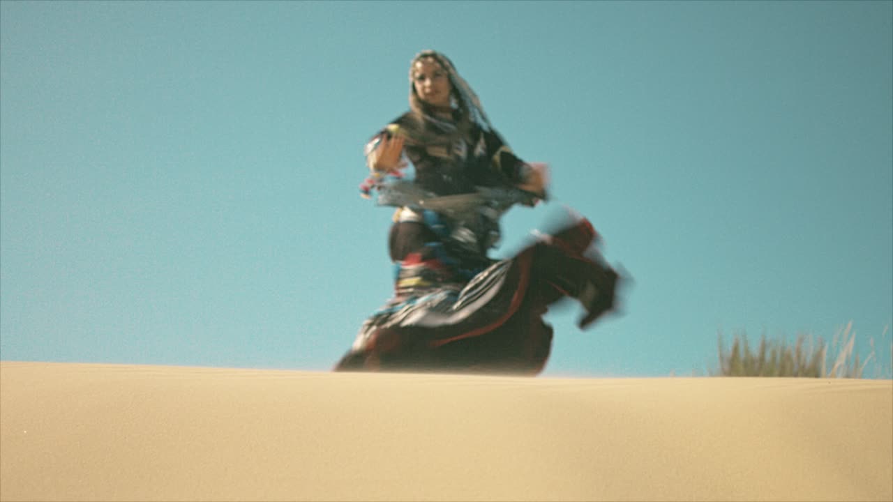 mujer gitana bailando y girando en una duna de arena del desierto