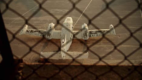 slow motion top shot of airplane on ground behind barbed wire netting, old abandoned airplane cinematic establishment shot, athens elliniko airport loneliness