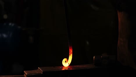 mid-section of blacksmith working on a iron rod