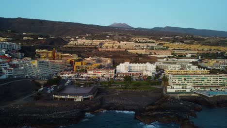 amazing drone shot in 4k spain tenerife los gigantes island volcano buildings hotels mountains seaside seashore water sea blue rocks pool