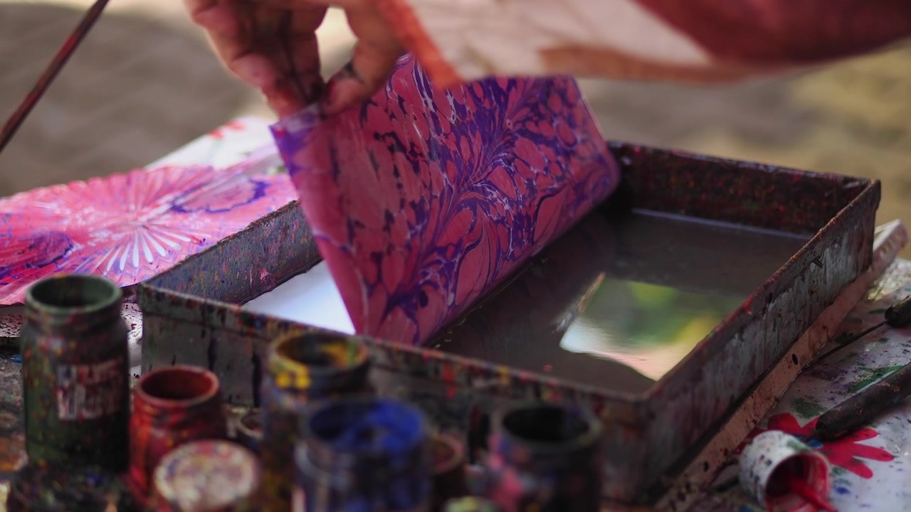 Artista che esegue l'arte tradizionale Ebru di marmorizzazione ad acqua