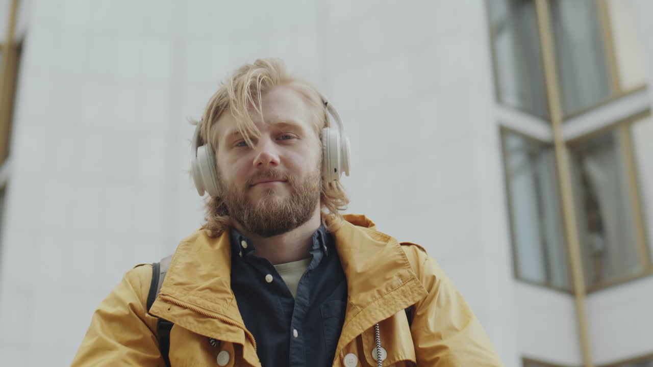 Portrait of Young Man in Headphones on City Street