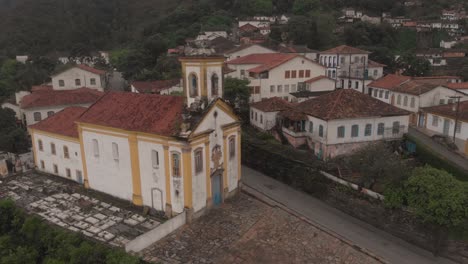 Aerial rotating pan showing the exterior facade of the Our Lady of Mercy and Charity church in Ouro Preto, Minas Gerais, Brazil, with a small cemetery beside
