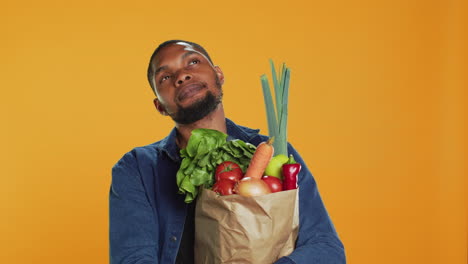 modelo masculino pensando en una nueva receta de comida vegana para cocinar