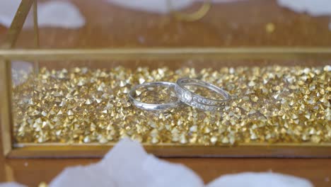 silver wedding ring veil in a gold box filled with golden stone