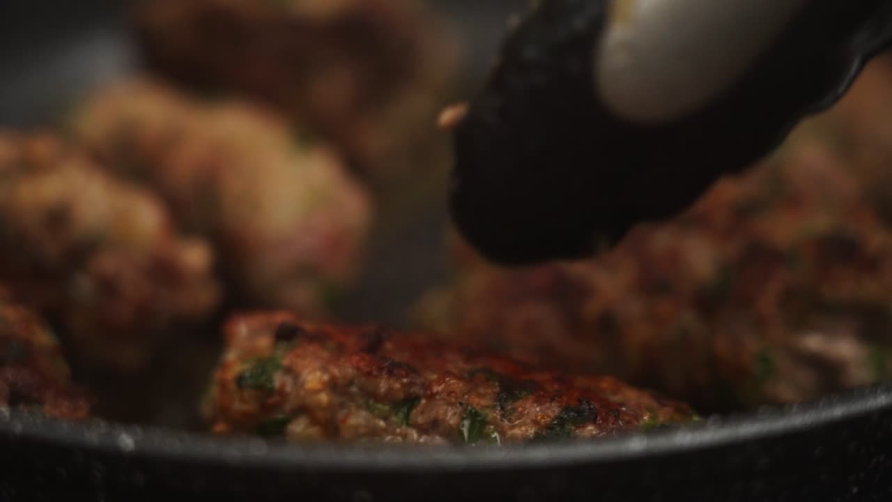 cocinero anónimo fritando bistecs de salisbury para el almuerzo