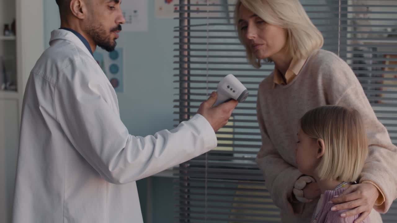 Doctor checking child's temperature