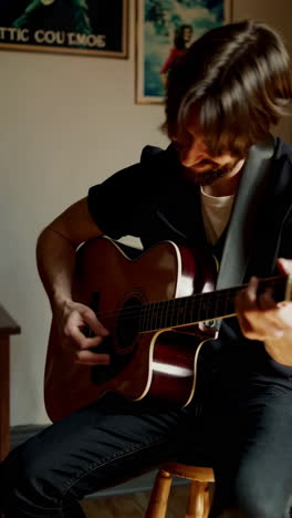 man playing acoustic guitar in a room
