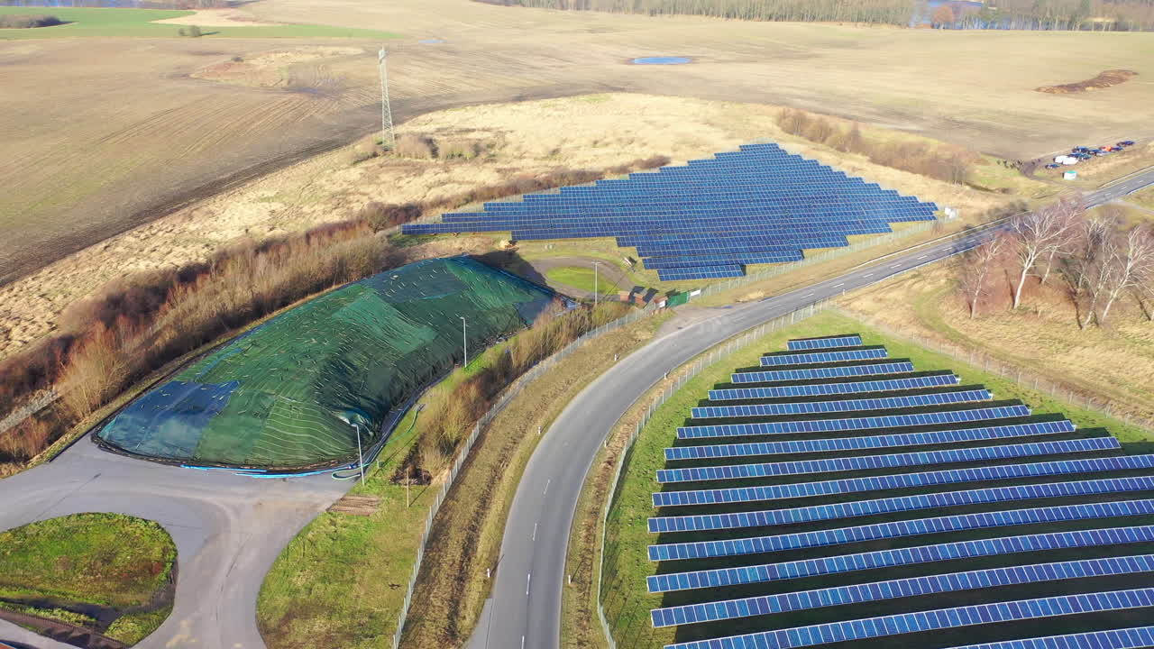 беспилотник пролетает над огромной фотоэлектрической установкой на открытом пространстве, состоящей из множества солнечных панелей