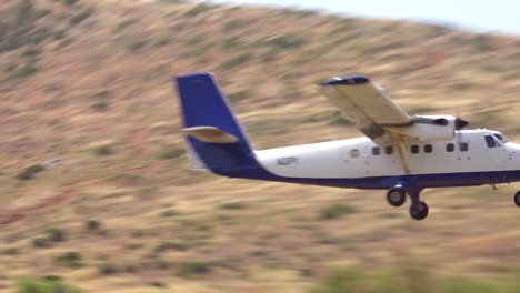 an unmarked twin engine plane takes off from a dirt airstrip