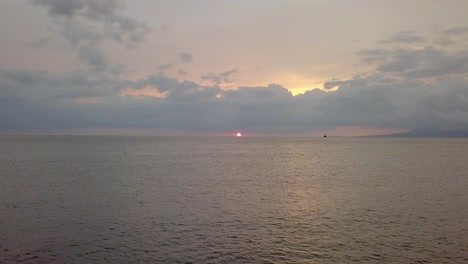 Relaxing-vibrant-sunset-over-the-ocean,-low-angle-aerial-dolly-shot