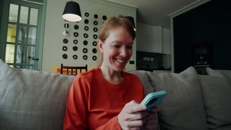 woman using smartphone on a couch