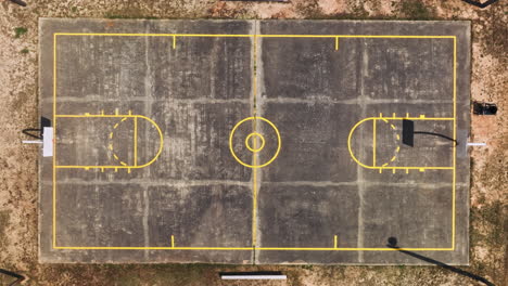 ascending overhead shot of empty amateur basketball court during golden sunset