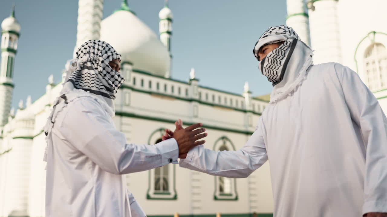 Two men in traditional Arabic clothing in front of a mosque