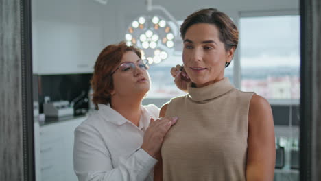 Beautician-showing-facial-treatment-result-to-woman-looking-mirror-close-up.