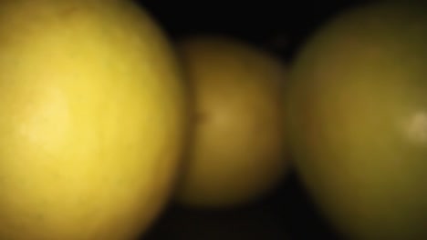 pulling away from 3 apples, one on the left is lit and focused while other 2 are in the shadows